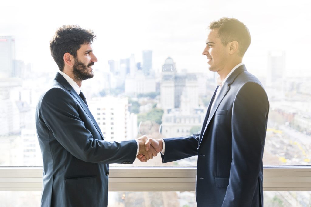 side view businessman shaking each other hands